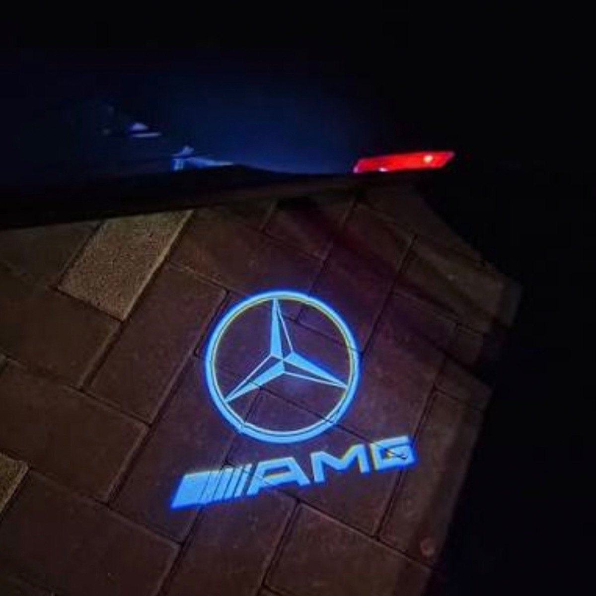 The same door with an AutoGlow Mercedes AMG logo light projected on the ground
